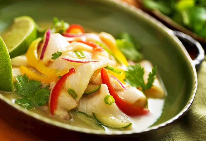 A freshly made white fish ceviche with red onion, red pepper, yellow pepper, cucumber, lime, and green onion.