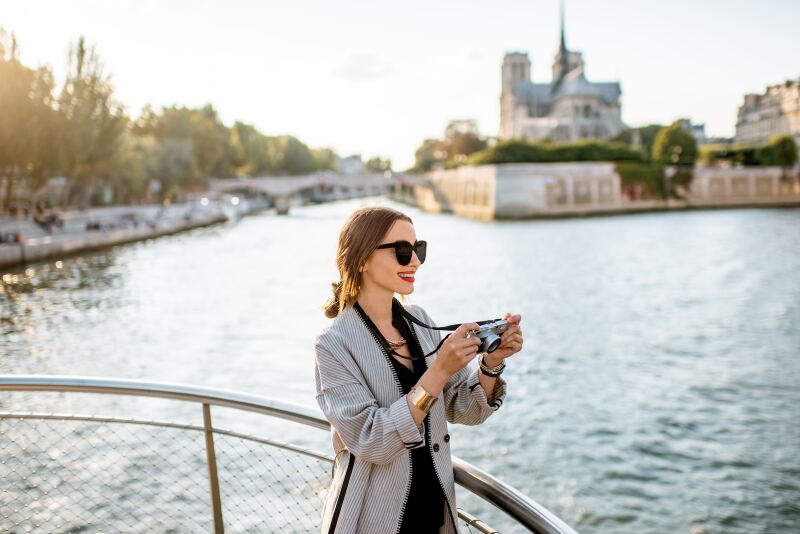A woman takes a picture while on a river cruise.