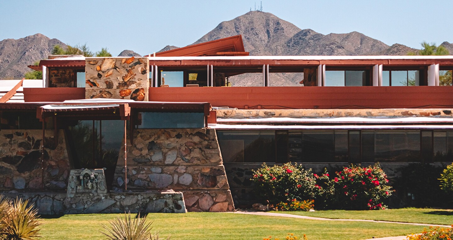 A red modern mansion in front of Southwestern mountains