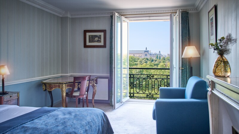 A junior suite at Hôtel Brighton, with glass doors open to views of the Tuileries Gardens