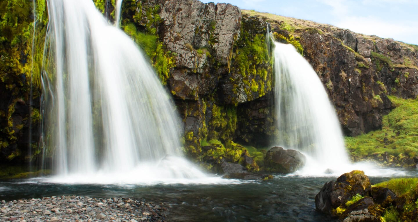Waterfalls from a moss-covered cliff