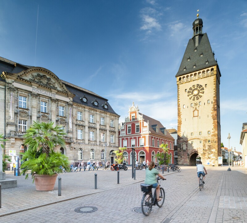 A person cycling towards the Old City Gate in downtown Speyer, Germany
