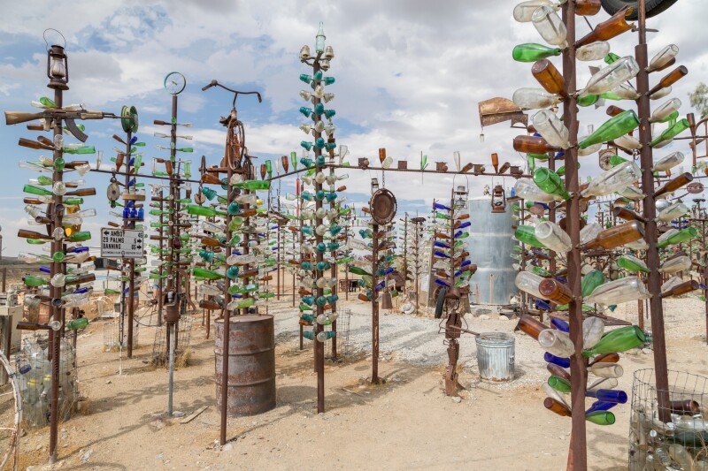 Tall poles with glass bottles as "branches" at Bottle Tree Ranch on historic Highway Route 66, Oro Grande California USA - September 03 2017