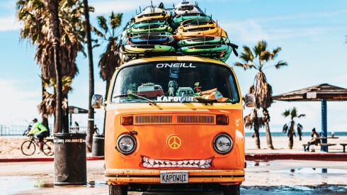 An orange van loaded with surfboards