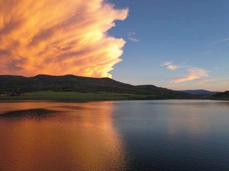 Orange clouds in sunset over a flat lake