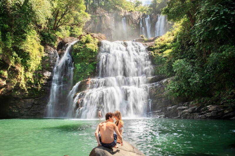 Two people enjoying a waterfall at Manuel Antonio National Park