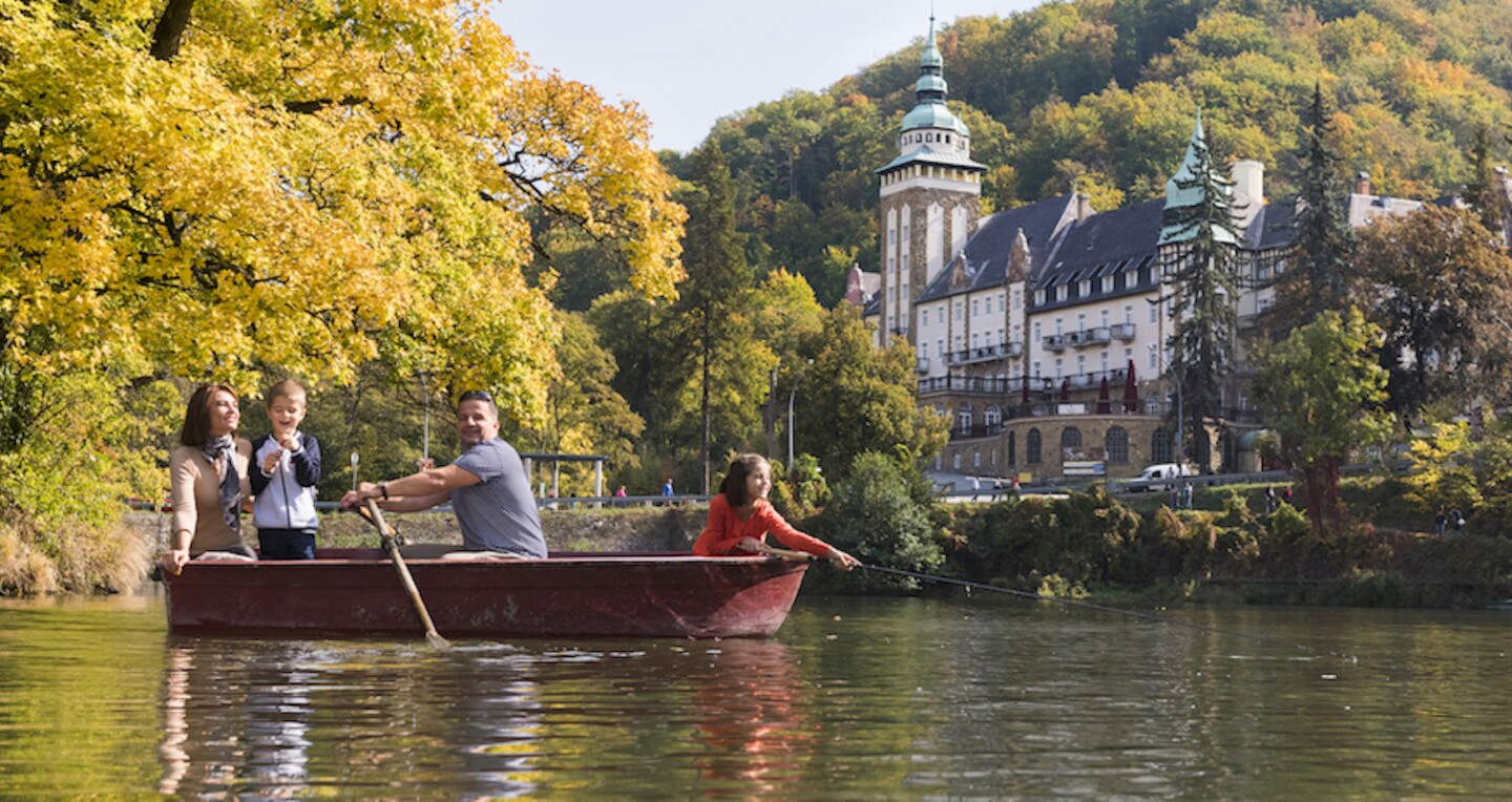 A family paddles down a river.