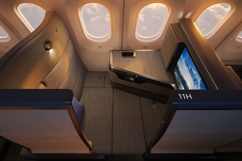 A Room FX business-class seat converted into a lie-flat bed, with two windows and large screen