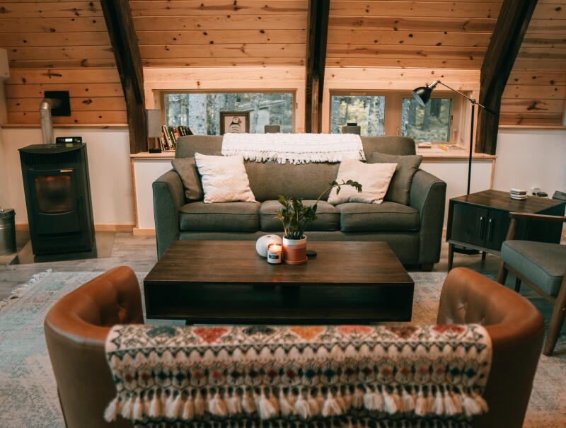 A-frame accommodations at Salted Roots with a tufted sofa and wooden walls