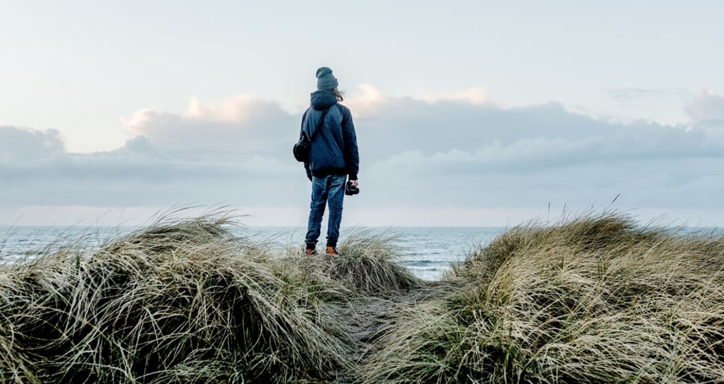 A photographer looks out over the sea.