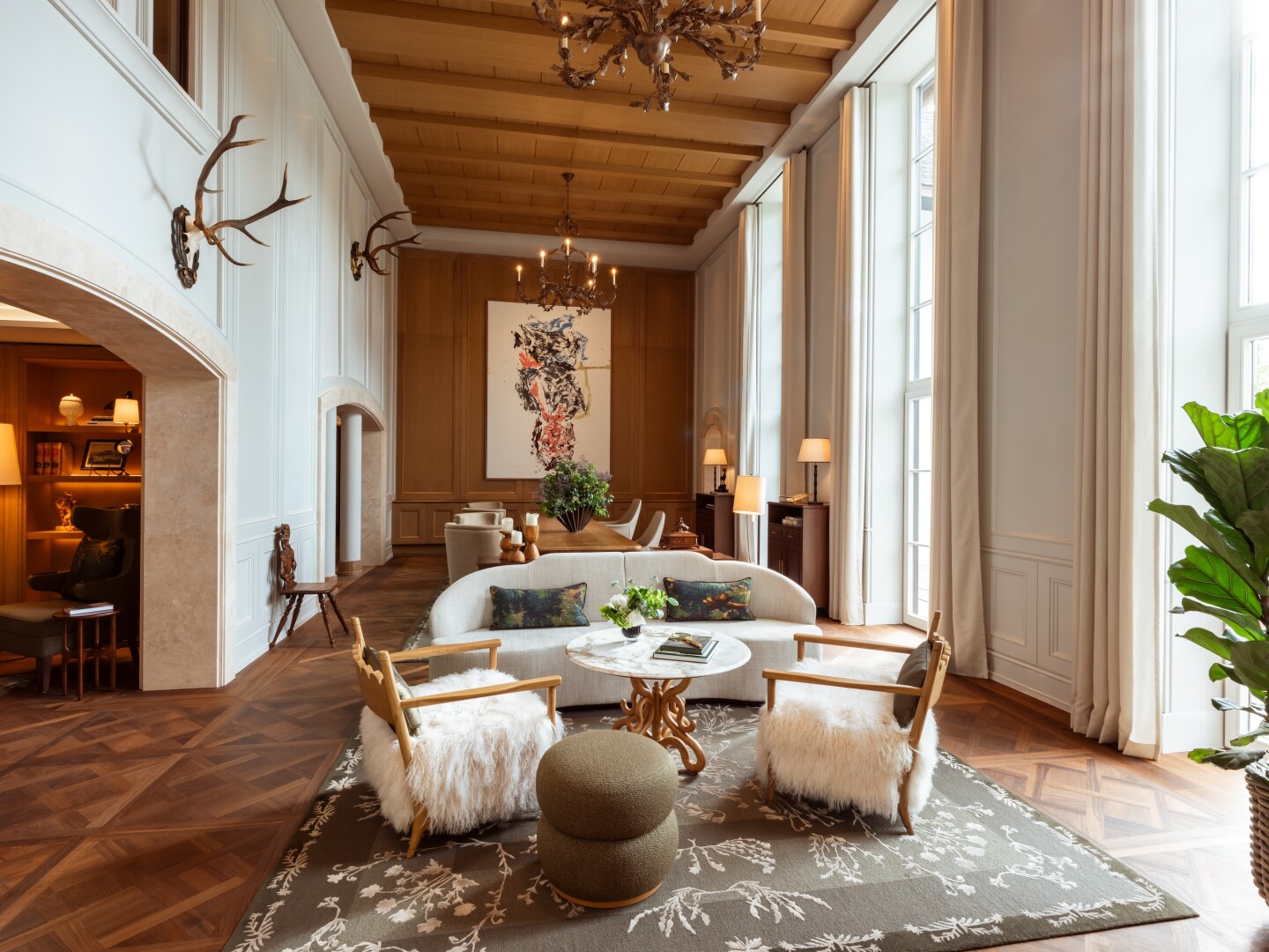 Rosewood Schloss Fuschl's reception area features hardwood floors, patterned carpets, and antlers on the walls.