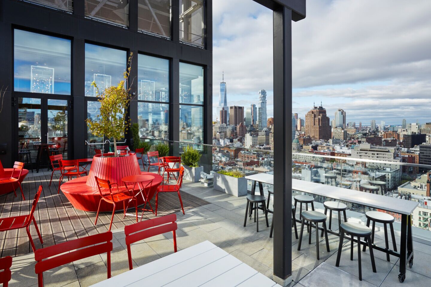 Outdoors at the rooftop bar at citizenM, with red seating and skyline views
