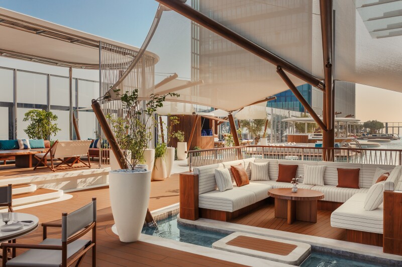 The outdoor seating areas at Tapasake restaurant, with white sofas shaded by white canvas coverings