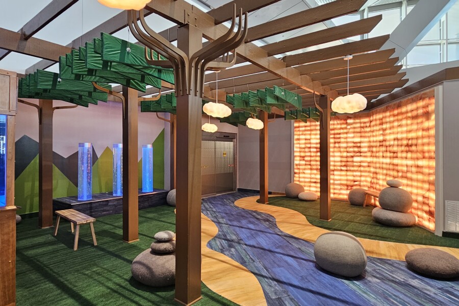 A sensory room for neurodivergent travelers at Newark Liberty International Airport, decorated to look like a stream running through a forest