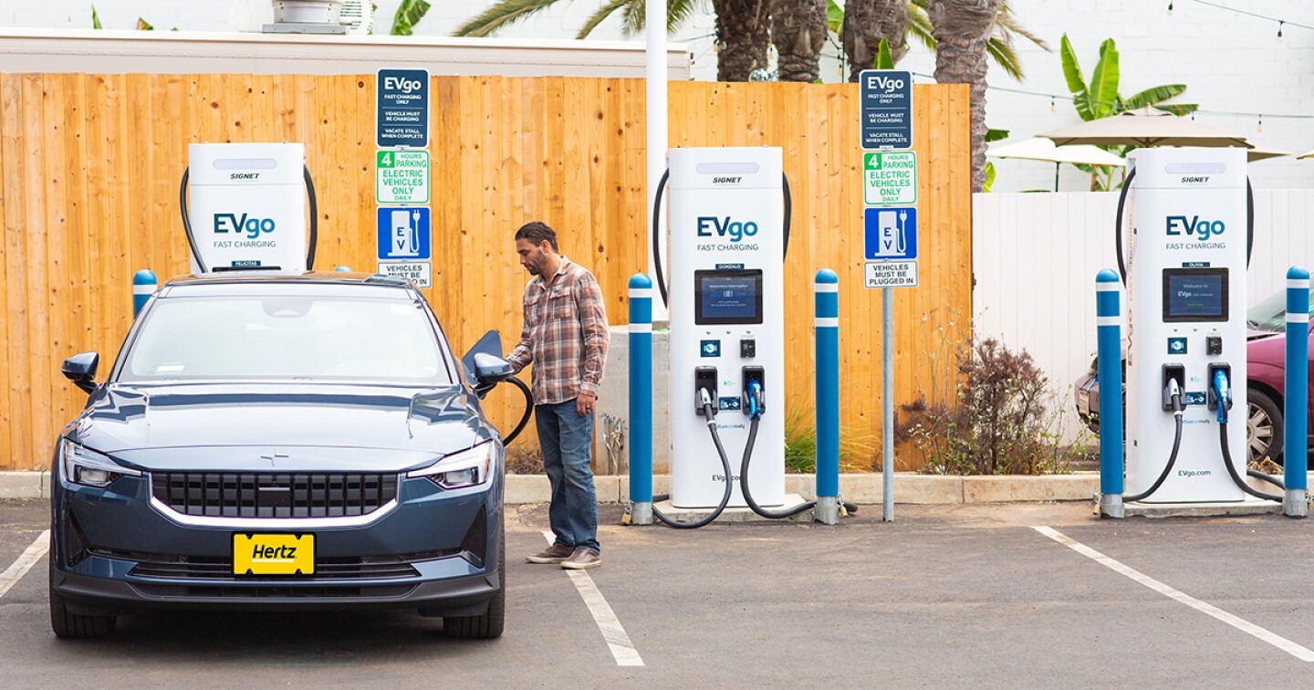An EVgo charging station fills up a Hertz rental car.
