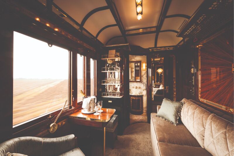 Paris Suite on the Venice Simplon–Orient-Express, with beige sofa facing large window