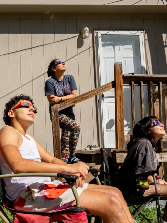Aamily watches the annular solar eclipse together on October 14, 2023 in Kerrville, Texas.