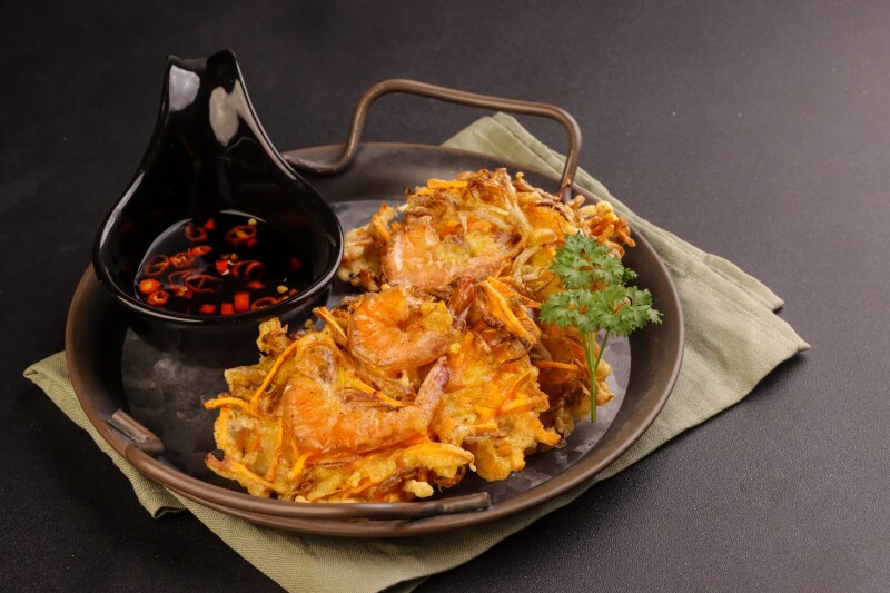 Fritters with shrimp on a plate with a sauce on the side