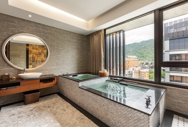 A private room at Chuang-Tang Spring Spa, with two pools next to large window overlooking city