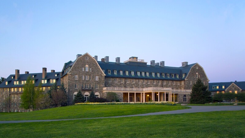 Exterior of large Skytop Lodge, surrounded by green lawn