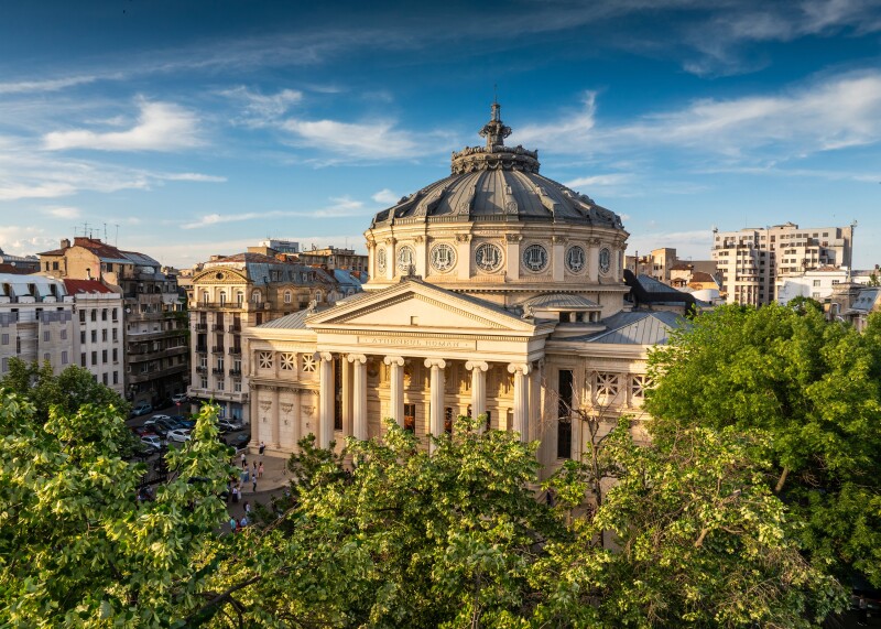 Romanian Atheneum in Bucharest during a summer sunset. Aerial view of this amazing landmark historical building from Bucharest, Romania, on Victoriei Avenue (Calea Victoriei).