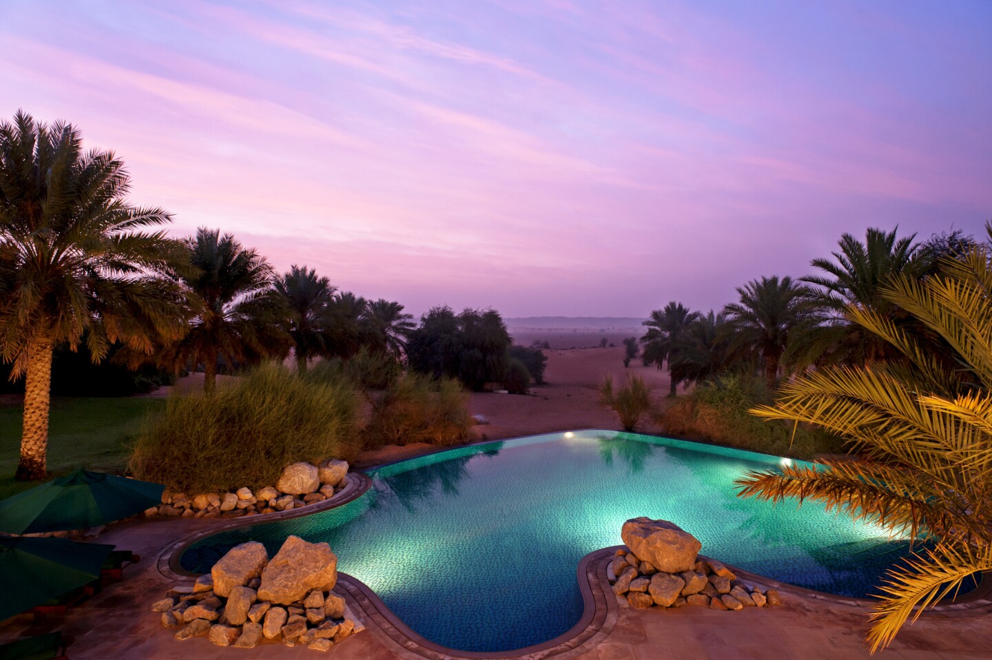 Exterior of accommodation with pool at sunset at Al Maha Conservation Reserve