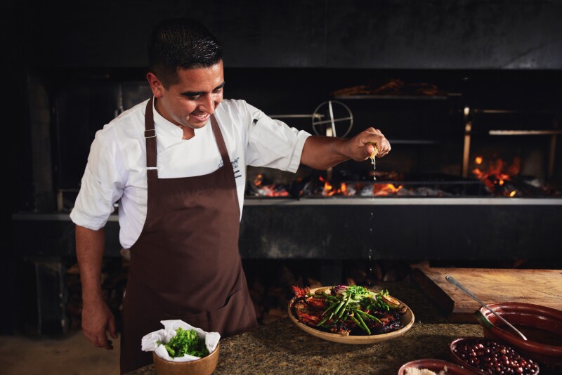 A chef putting the finishing touches on a dish at Fuego restaurant, Fairmont Mayakoba.