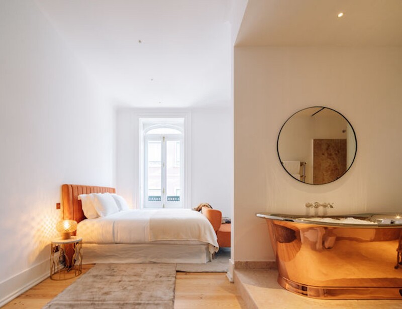A white "dream bath" guest room at Palacio Principe Real with large copper tub