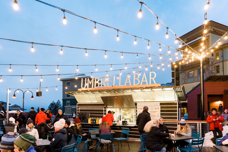 People dining at tabled in front of the outdoor eatery Umbrella Bar in Park City, Utah.