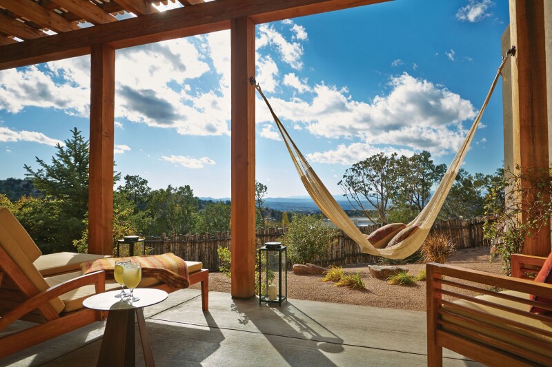 Wooden suite patio at the Four Seasons Resort Rancho Encantado Santa Fe, with two chairs and a hammock