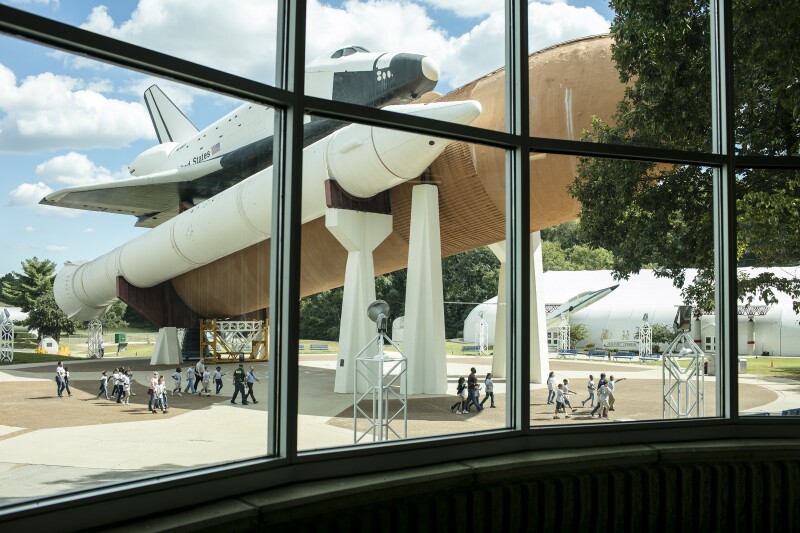 Space camp attendees walk under The Space Shuttle Orbiter Pathfinder in Huntsville Alabama. The Pathfinder is a Space Shuttle test simulator made of steel and wood, constructed by NASA in 1977 as a test article.
