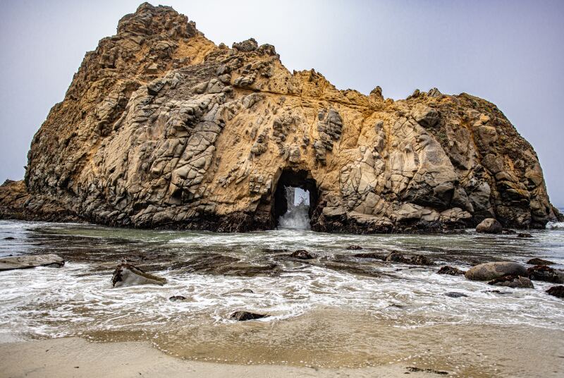 Large offshore rock with small cave, known as Keyhole Arch, off Pfeiffer Beach