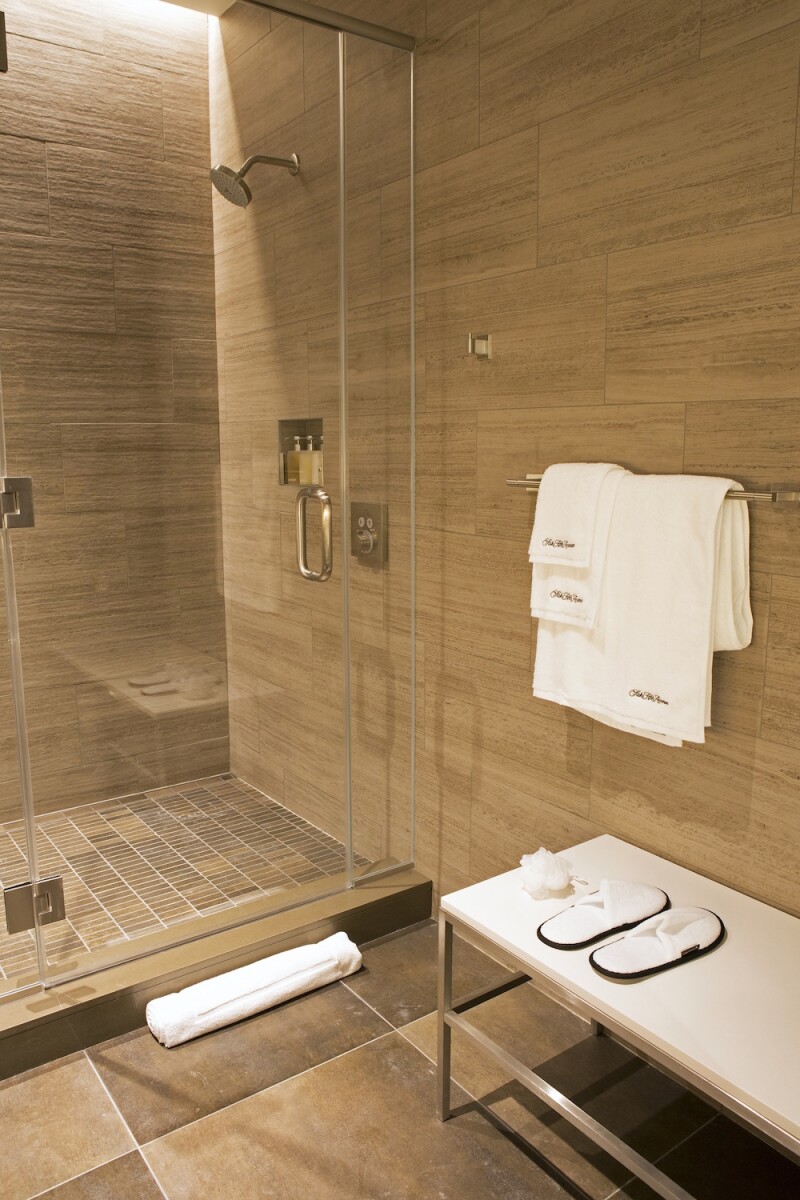A private shower at United Polaris business class lounge, complete with slippers