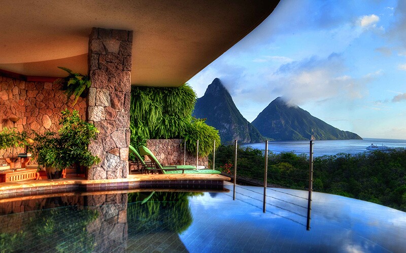 A view of a shallow hotel pool overlooking St. Lucia's iconic pitons