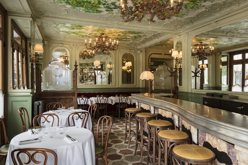 interior of old-fashioned Parisian bistro, with zinc bar and chandeliers