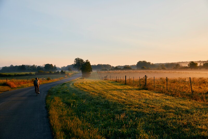 Bike rider in rural landscape at dawn