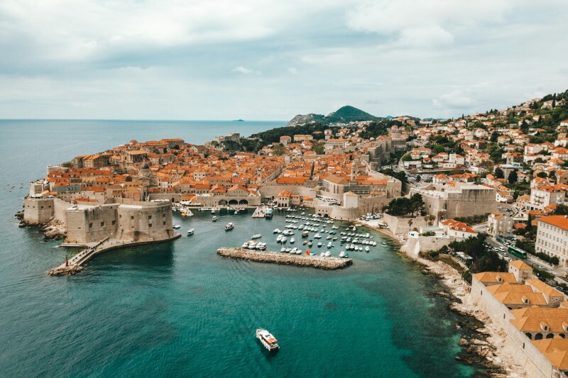 An aerial view of coastal Old Town Dubrovnik, with small harbor