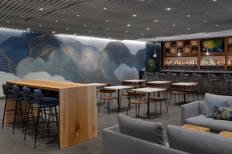 The new bar inside the recently expanded Centurion Lounge at San Francisco International Airport, with blond wood furniture and gray sofas