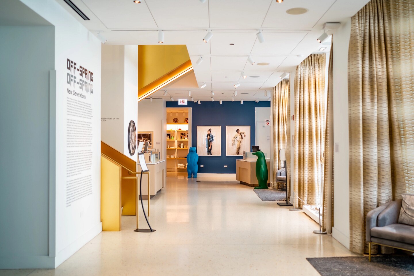 An art-filled lobby at the 21C Museum Hotels Chicago, with a blue bear statue, green penguin statue, and large photographs on blue wall