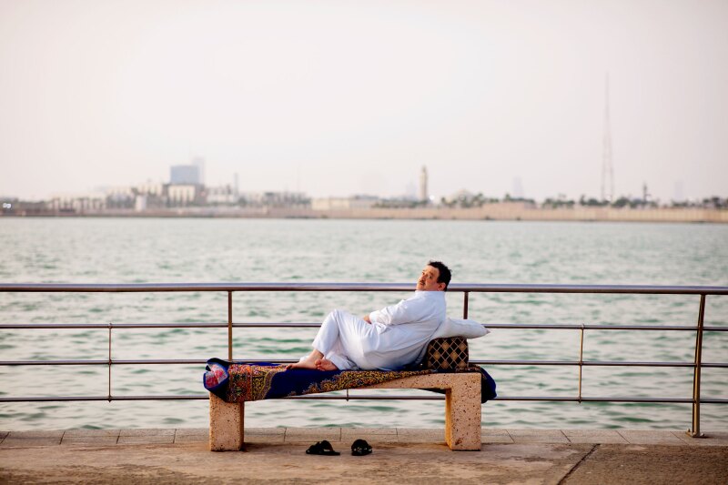 A man rests in front of the Jeddah Corniche