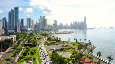 A park-lined waterfront in Panama City with a large collection of skyscrapers in the background