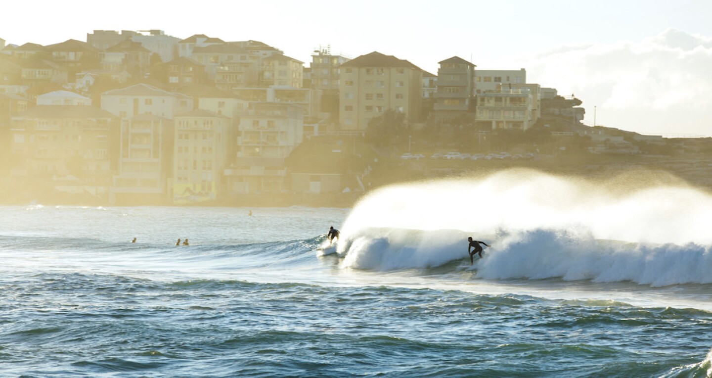 Surfers catching a morning wave at Bondi Beach in Sydney's eastern suburbs.