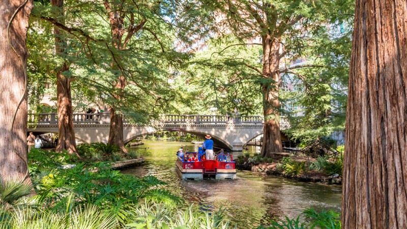 A small boat on the tree-shaded river in San Antonio