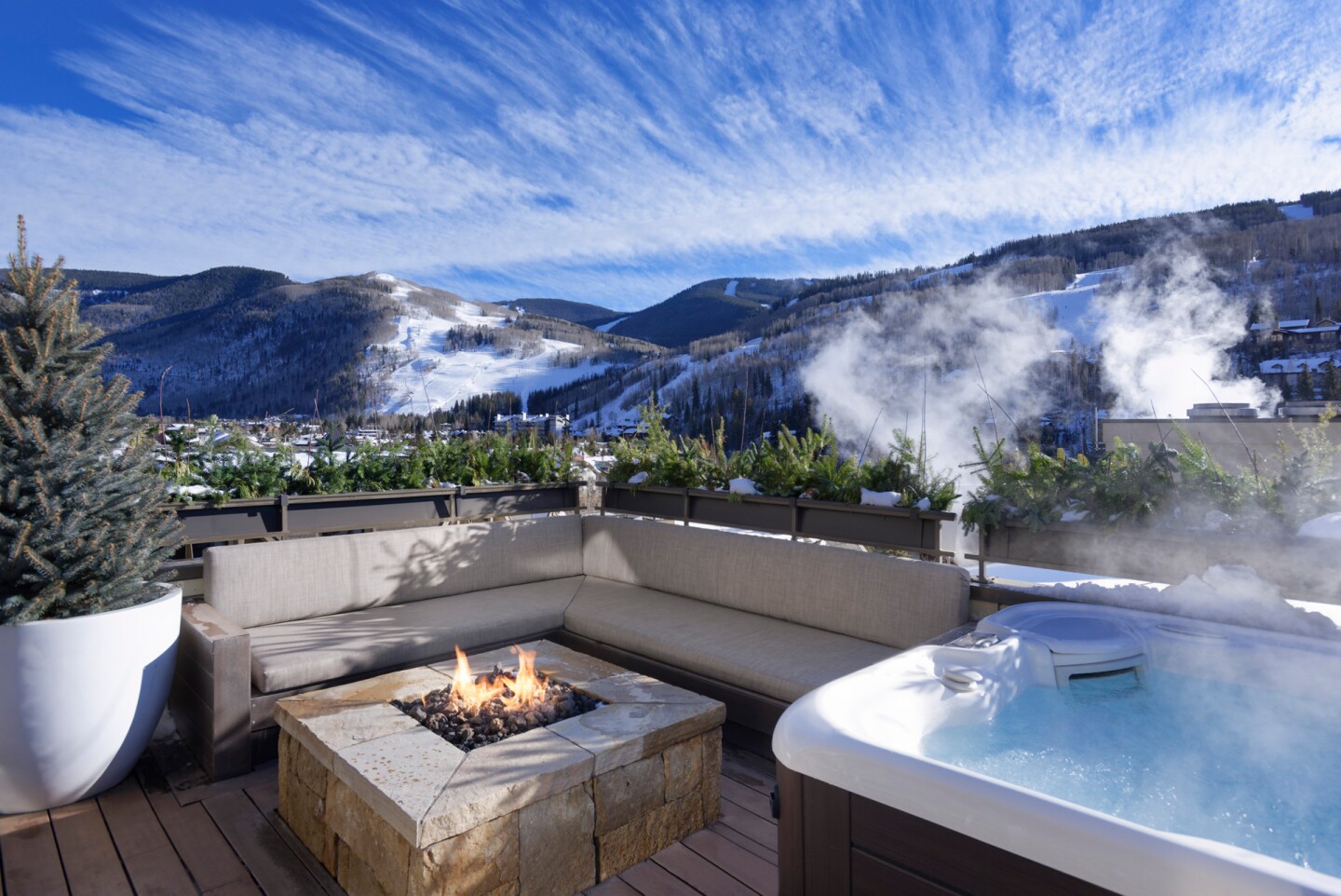 Deck at Four Seasons Vail Private Residences, with private whirlpool, firepit, and bench seating overlooking mountains