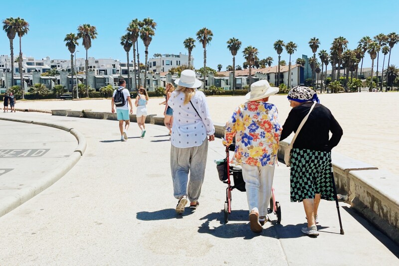 A few people walking next to beach at Santa Monica