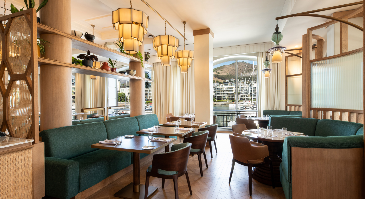 The restaurant at Cape Grace has geometric chandeliers and green banquette seating.