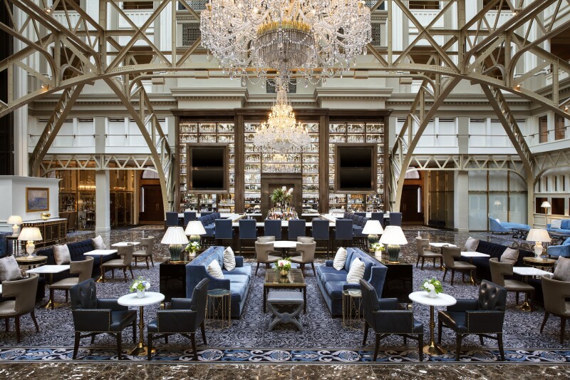 Cafe tables and couches under chandeliers in the Waldorf Astoria Washington DC