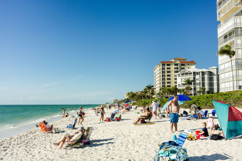 Naples, Florida - March 6, 2018: Tourists enjoying the Vanderbilt beach in Naples, Florida. Naples is located on the Gulf Coast in southern Florida.