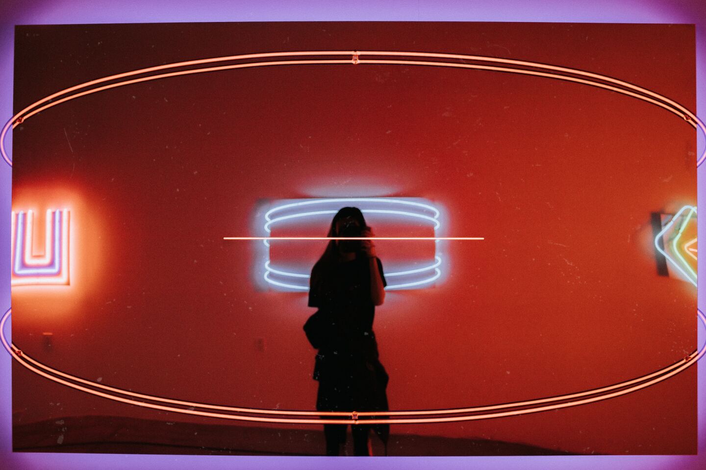 A person standing in a mirrored display at the Museum of Neon Art in Glendale, California.