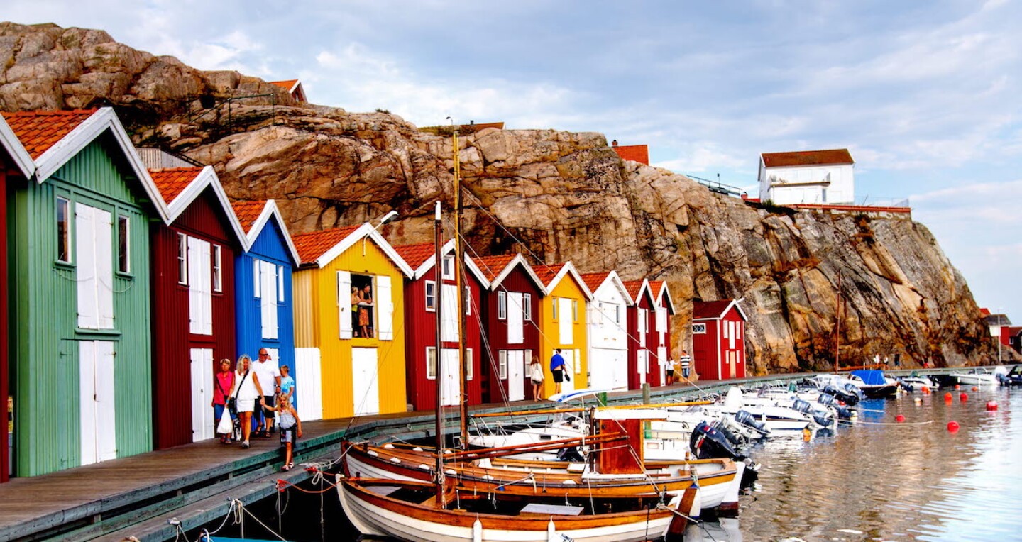 Colorful houses by the water. Some houses are on a cliff above.
